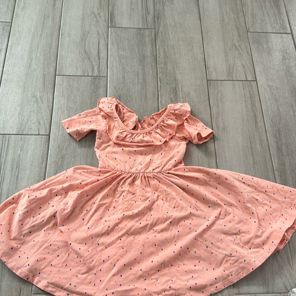 Adorable sprinkle dress with trim around the neck.